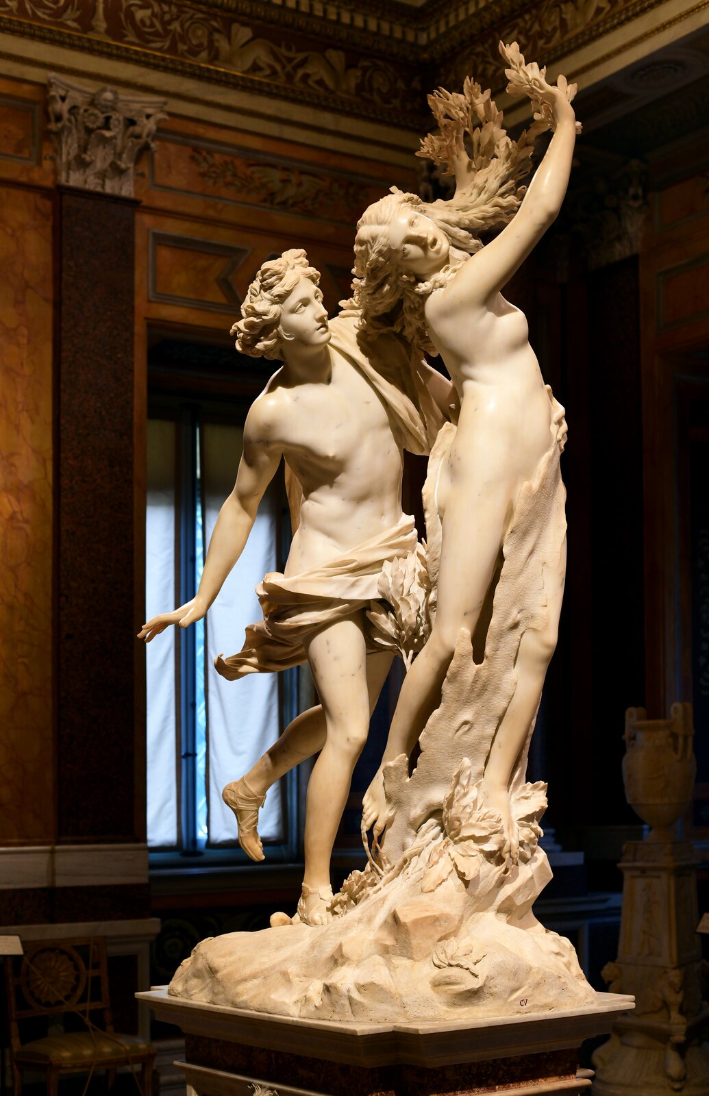 Ilustracja przedstawia marmurową rzeźbę Giovanni Lorenzo Berniniego „Apollo i Dafne”. Bernini uwiecznił w formie rzeźby moment przemiany Dafne w krzak wawrzynu (drzewo laurowe). Apollo uważany za boga piękna zakochał się w Dafne. Ta, daremnie próbując uciec od zakochanego, uprosiła matkę, aby zmieniła ją w drzewo wawrzynu. Dafne jest symbolem miłości niedostępnej i dziewictwa.