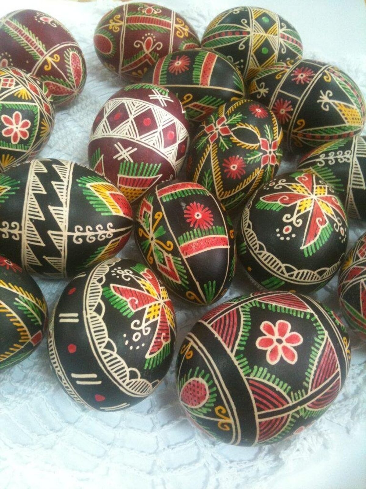 Zdjęcie prezentuje kolorowe, malowane jajka. Wzory geometryczne i kwiatowe. Pisanki nawiązują do tradycji ludowej. 