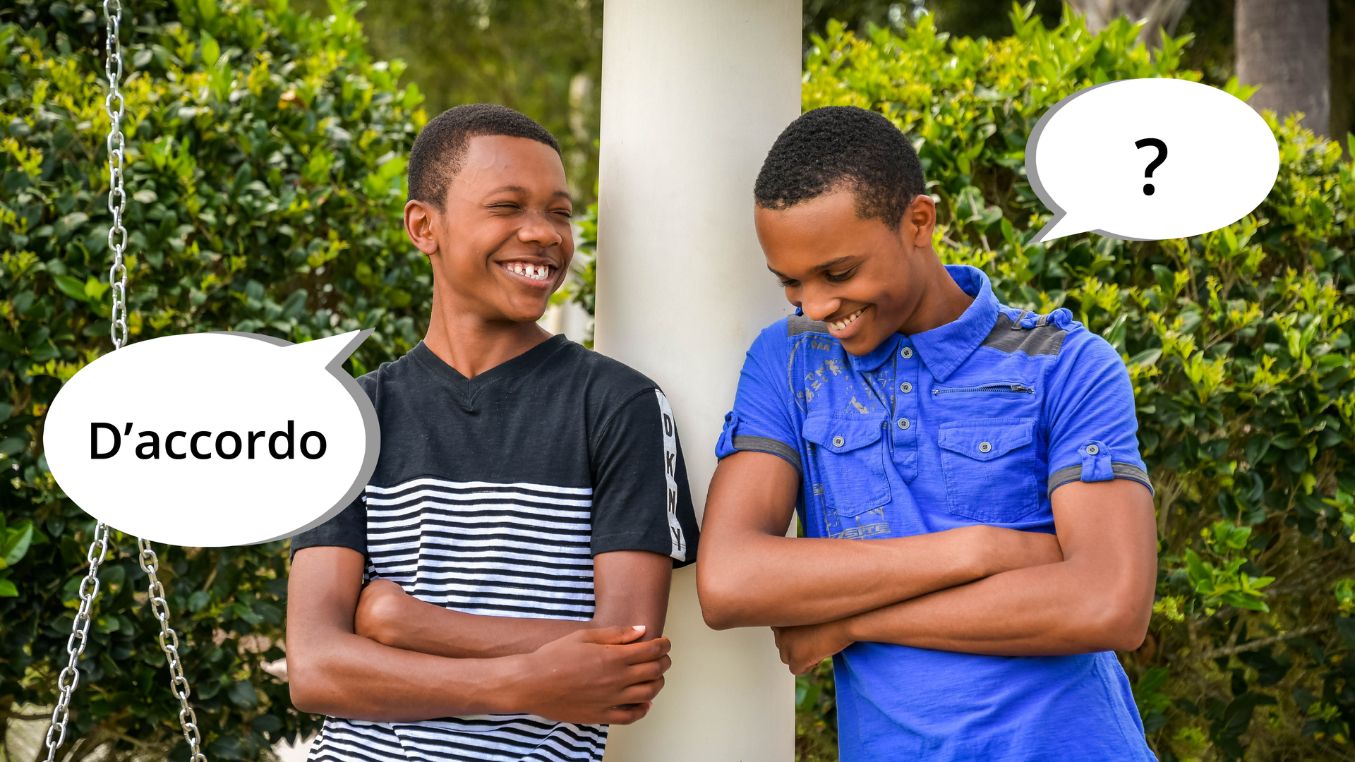 Zdjęcie przedstawia dwóch śmiejących się ciemnoskórych chłopaków opartych o kolumnę jakiegoś budynku. Obok chłopaka po lewej stronie znajduje się dymek z tekstem: "D'accordo". Obok chłopaka po prawej stronie znajduje się dymek ze znakiem zapytania.