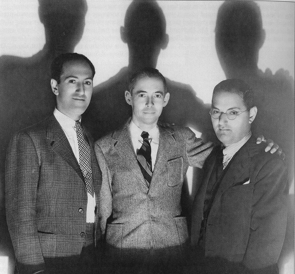 Trzech twórców opery Porgy and Bess – (od lewej) George Gershwin, DuBose Heyward, Ira Gershwin. Ubrani elegancko w garnitury i białe koszule, są uśmiechnięci i mają przyjazne wyrazy twarzy. Gershwin jako jedyny nosi okulary.