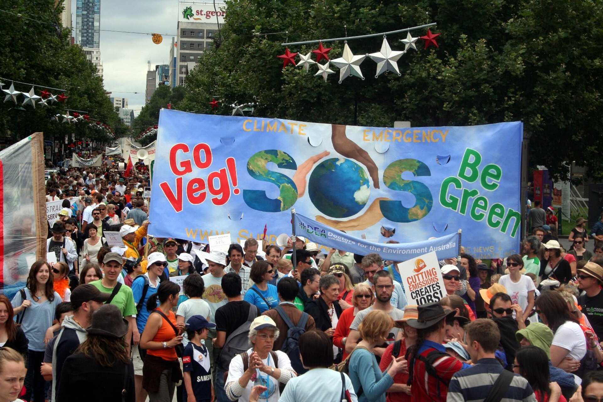 Na zdjęciu manifestacja w Melbourne w Australii w obronie klimatu. Manifestanci domagają się większej dbałości od polityków o klimat na Ziemi i doprowadzenie do zmniejszenia emisji dwutlenku węgla. Na zdjęciu wielki, kolorowy tłum ludzi maszerujący ulicą. Ludzie trzymają transparenty.