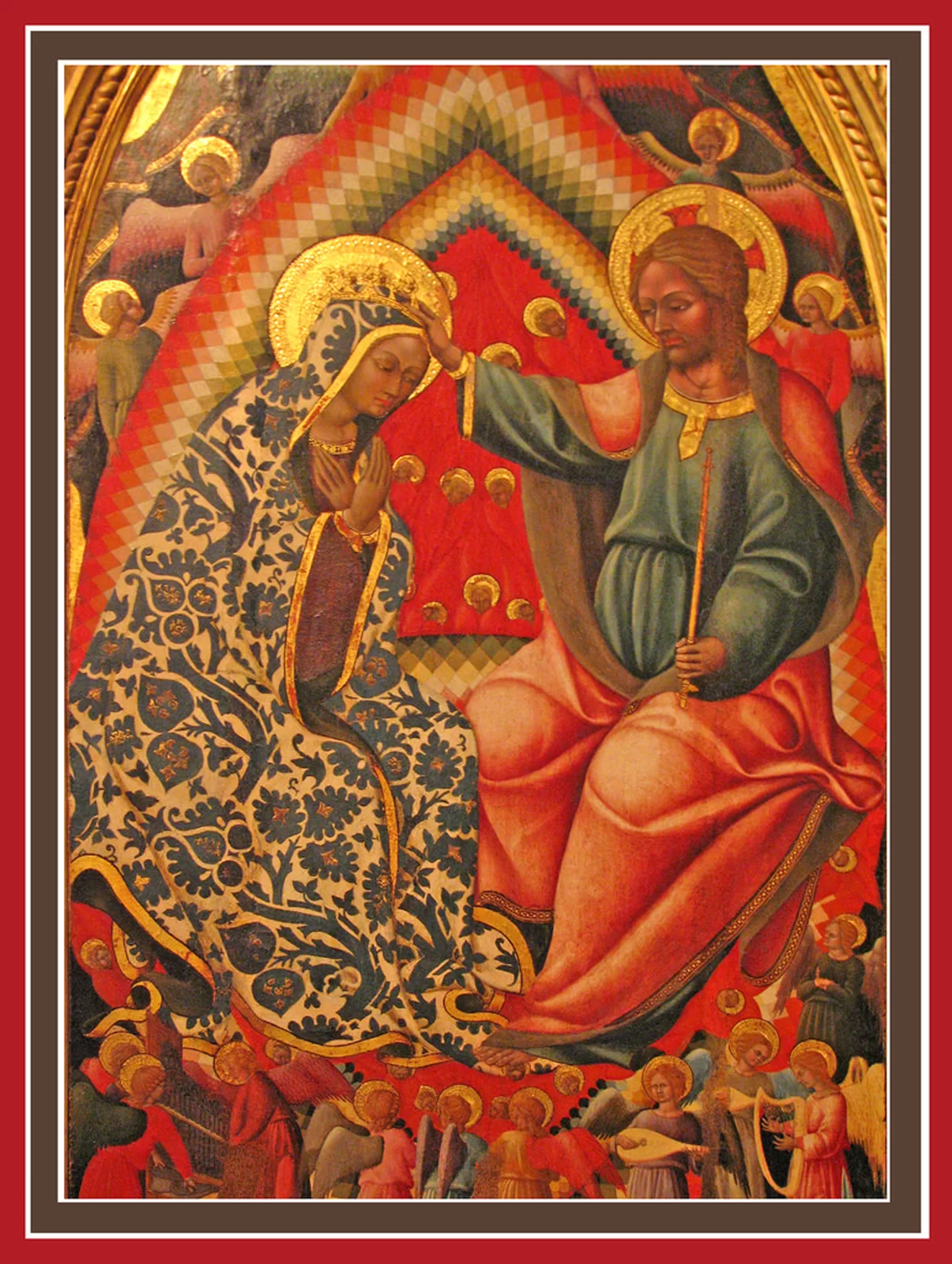 Ilustracja przedstawia obraz Bartolomea di Tommasa „Koronacja Najświętszej Marii Panny”. W centrum znajduje się ubrana w kwiecisty płaszcz Matka Boska i Chrystus. Siedzą naprzeciw siebie na tronie, zwieńczonym trójkątną tęczą, a ich głowy otaczają złote nimby. Jezus zakłada na głowę Matki Boskiej koronę. Scenę ze wszystkich stron otaczają aniołowie. W dolnej części aniołowie grają na instrumentach.