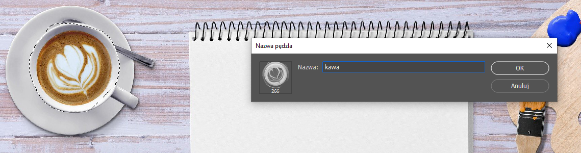 Ilustracja przedstawia prostokątne zdjęcie. Po lewej stronie jest filiżanka z kawą, w filiżance otoczono okręgiem jej brzeg, po prawej notatnik. Na tle notatnika jest okno o nazwie: Nazwa pędzla. W nazwie wpisano: kawa. Obok jest wizerunek górnej części filiżanki, czyli kawy ze wzorkiem serca. 
