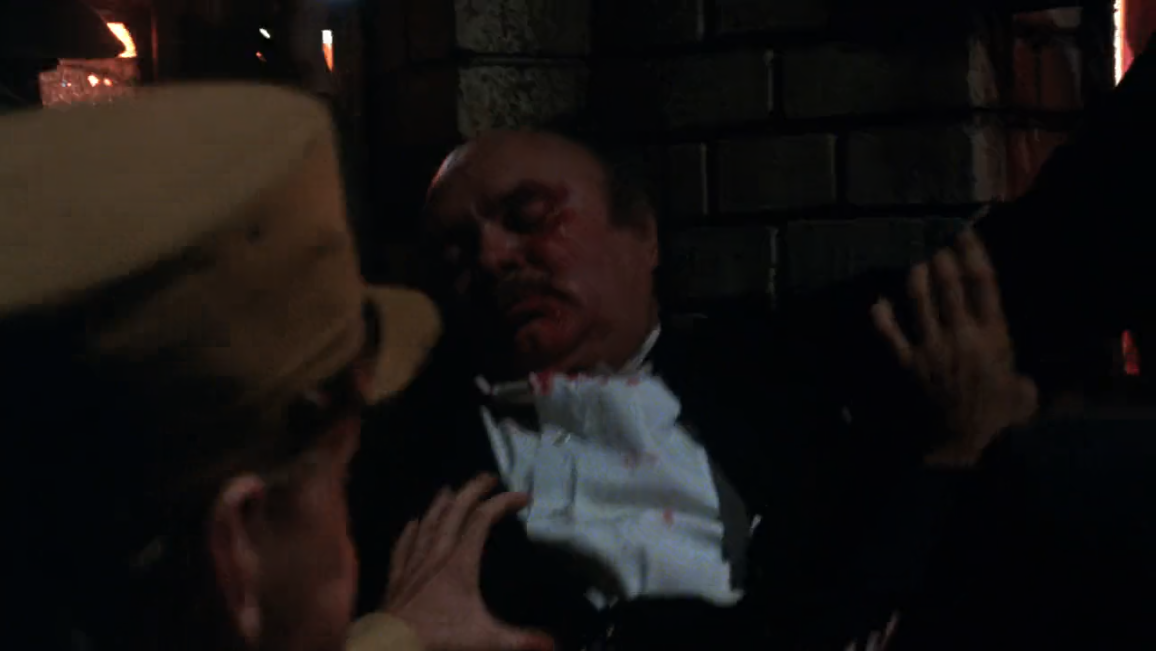 Zdjęcie przedstawia mężczyznę w garniturze z zakrwawioną twarzą.