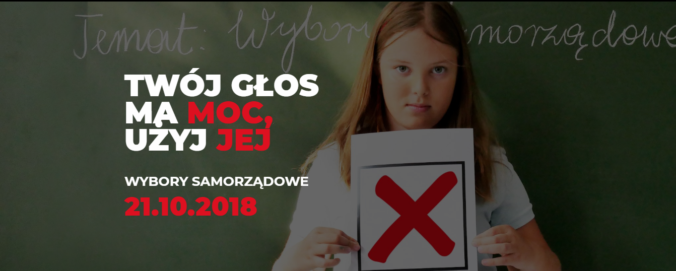 Kliknij żeby powiększyć Tło zdjęcia stanowi szkolna tablica. Widnieje na niej napis: temat: Wybory samorządowe. Na środku stoi dziewczynka. Trzyma kartkę z zaznaczonym znakiem x. Po lewej stronie są napisy: Twój głos ma moc, użyj jej. Wybory samorządowe 21.10.2018.
