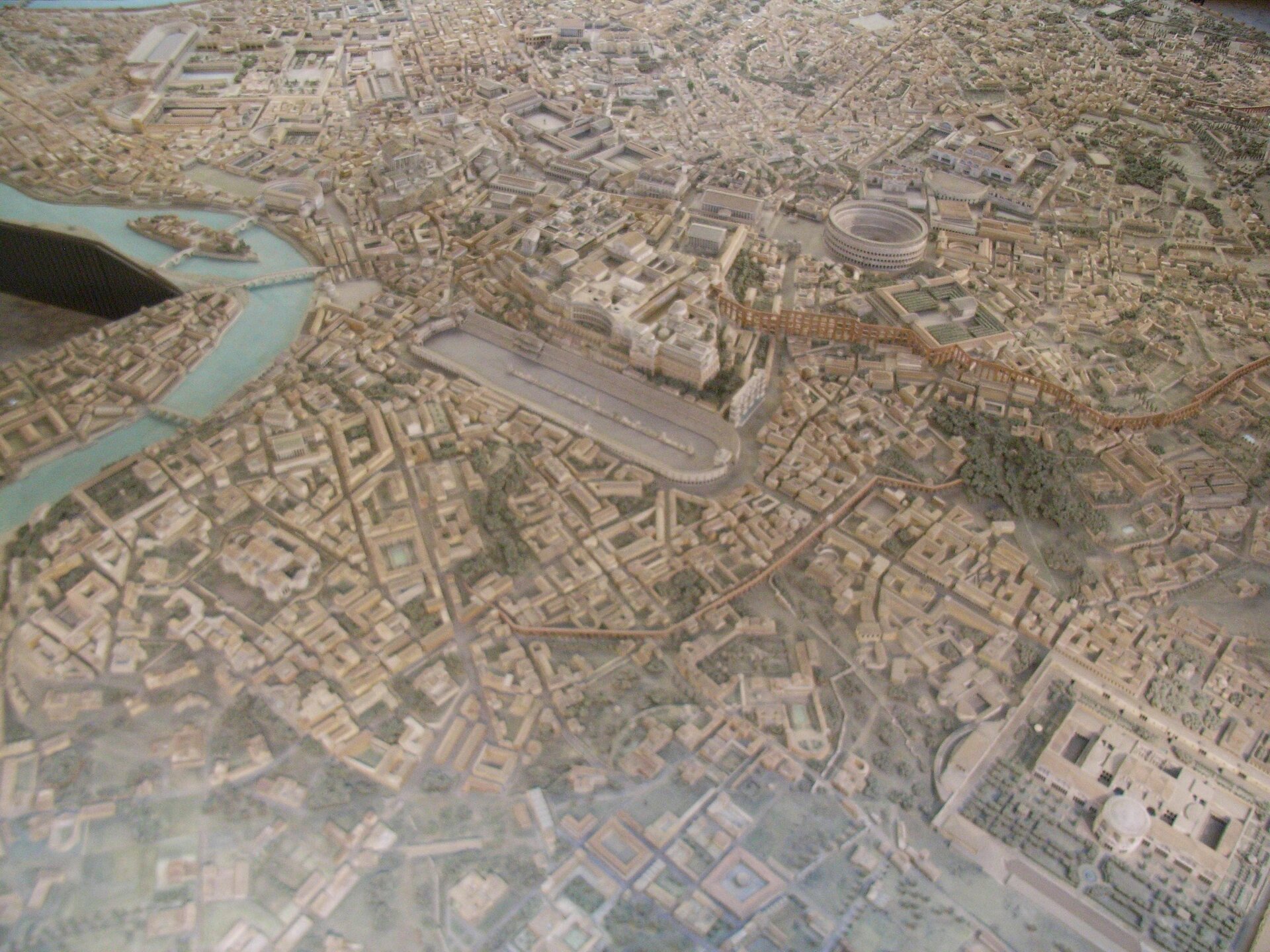 Ilustracja przedstawia widok z góry na makietę starożytnego Rzymu. Bardzo gęsta i zwarta zabudowa. Z lotu ptaka przypomina miasta współczesne jeśli chodzi o gęstość zabudowy, siatkę ulic, a także rozmiary samego miasta.