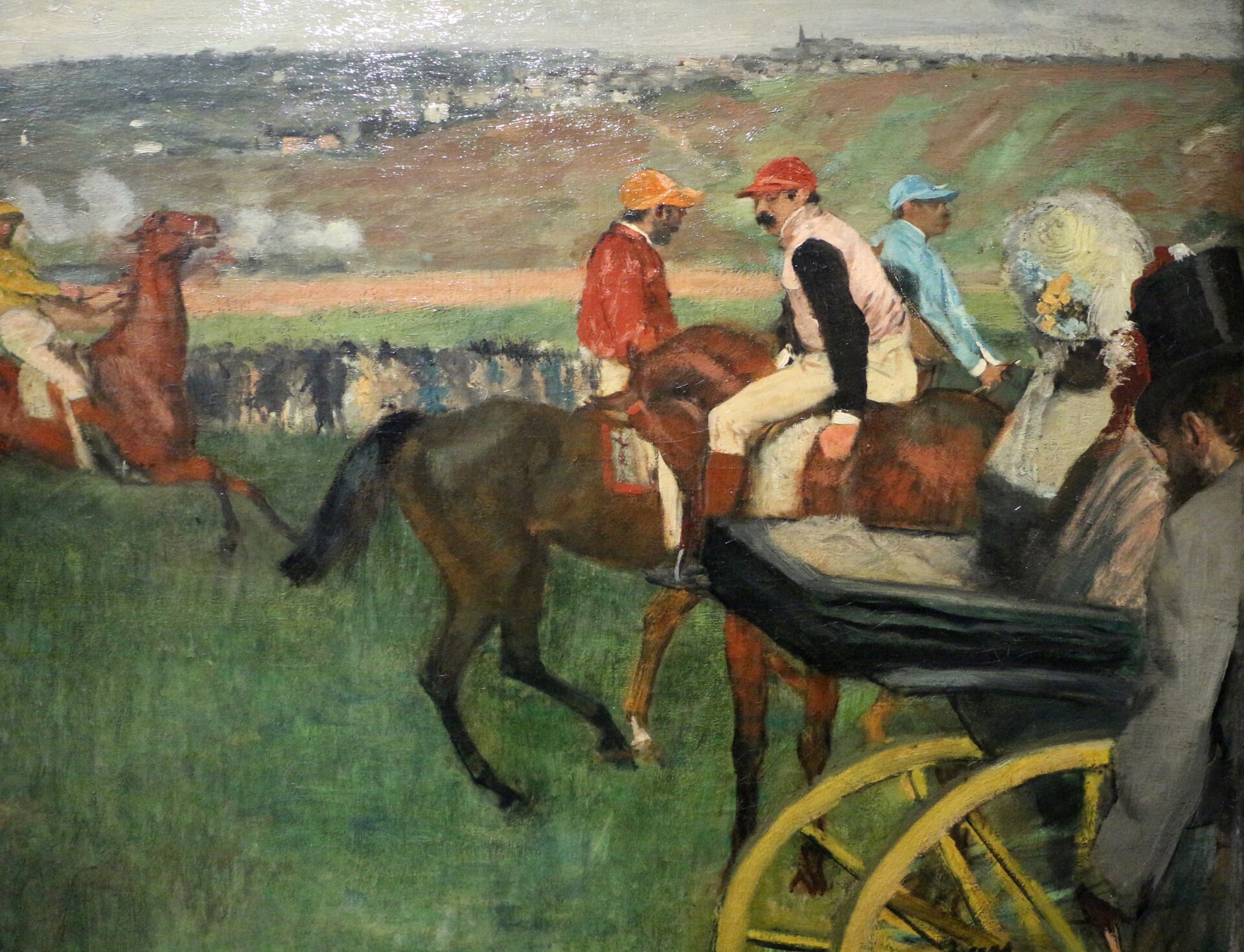 Ilustracja o kształcie poziomego prostokąta przedstawia obraz Edgara Degasa „Na wyścigach”. Ukazuje grupę jeźdźców na koniach. Po prawej stronie widać część powozu z  siedzącą na nim kobietą oraz fragment postaci w szarej marynarce i kapeluszem na głowie. Kobieta ma na głowie biały kapelusz z przypiętymi kwiatami Postacie te zwrócone są tyłem do widza, patrzą w stronę  wyścigu. Tłem jest pagórkowaty pejzaż z dalekim widokiem na miasto.   