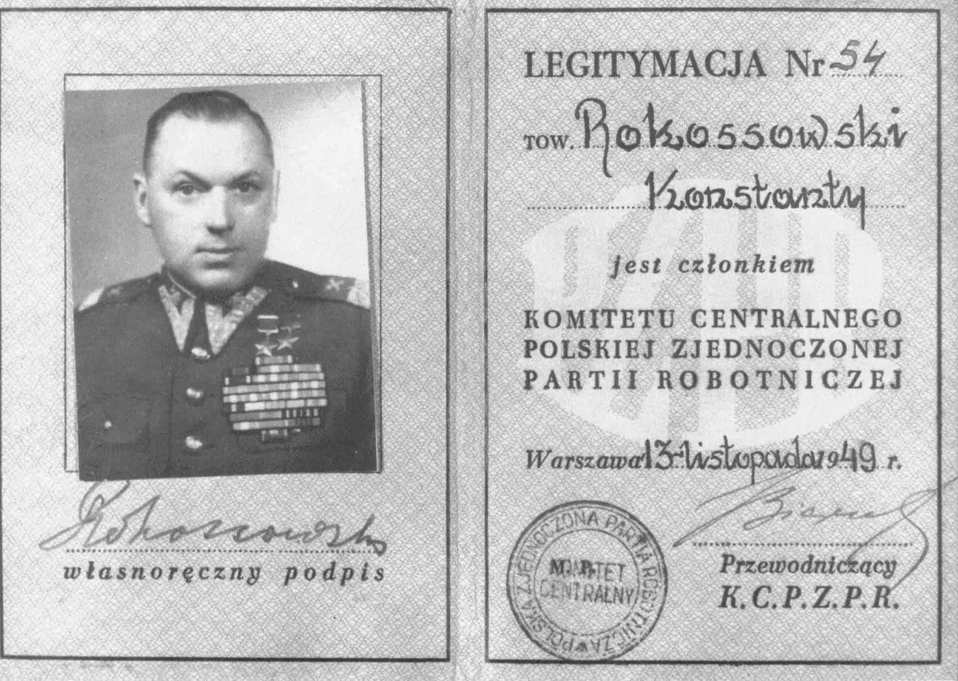 Kliknij żeby powiększyć Zdjęcie. Na legitymacji po lewej stronie znajduje się zdjęcie mężczyzny w mundurze. Na piersi zawieszone są odznaczenia i medale. Pod zdjęciem jest odręczny podpis. Po prawej stronie legitymacji znajduje się napis: Legitymacja nr 54. Tow. Rokossowski Konstanty jest członkiem KOMITETU CENTRALNEGO POLSKIEJ ZJEDNOCZONEJ PARTII ROBOTNICZNEJ. Warszawa 13 listopada 49 rok. Pieczątka i podpis: Przewodniczący K.C.P.Z.P.R.