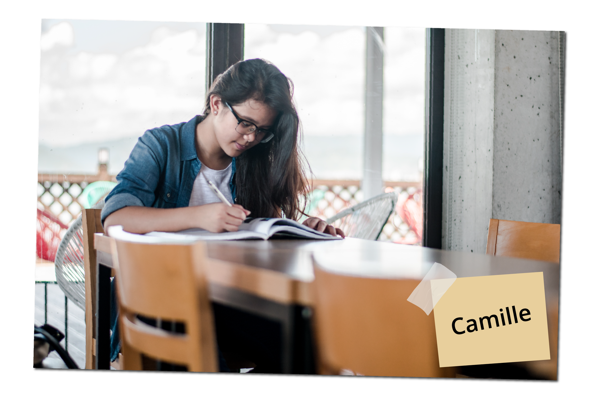 Na zdjęciu widoczna jest dziewczyna siedząca przy stole. Trzyma otwartą książkę i długopis w ręce. Ma brązowe włosy i nosi okulary. Na zdjęciu znajduje się podpis: Camille.