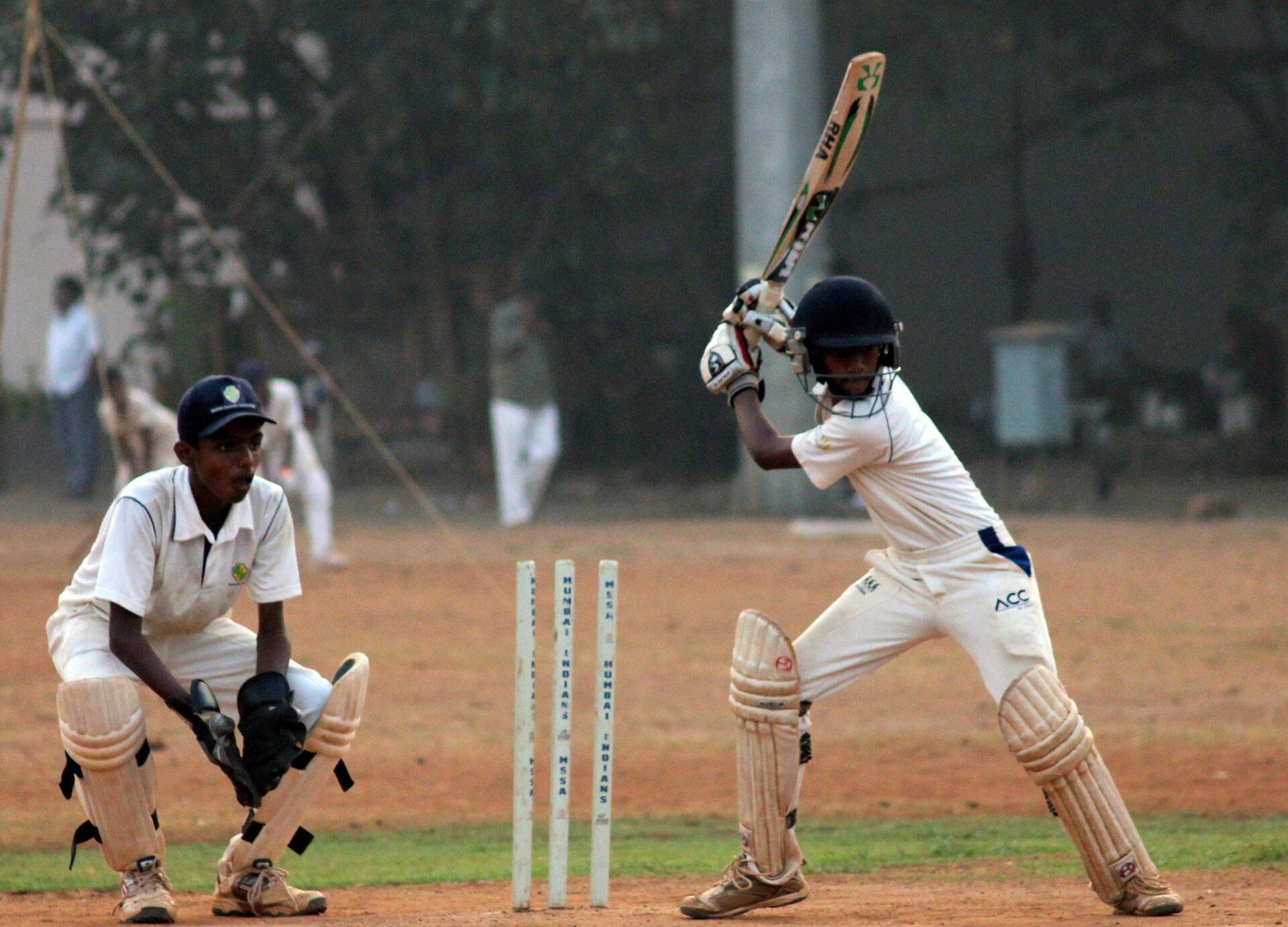 Zdjęcie przedstawia dwóch zawodników grających w krykieta.  