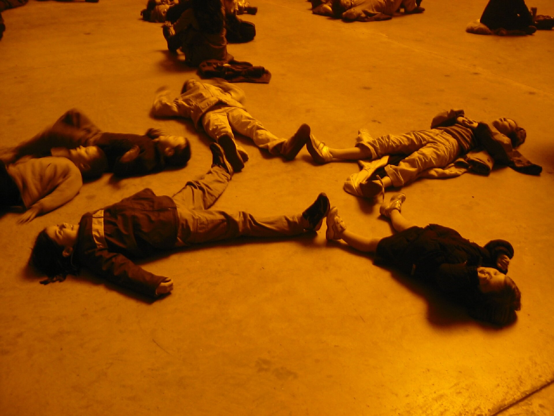 Projekt Olafura Eliassona „The weather project” w Galerii Tate Modern w Londynie. Na zdjęciu cztery osoby leżą na ziemi - dotykając się nawzajem stopami, tworzą okrąg.