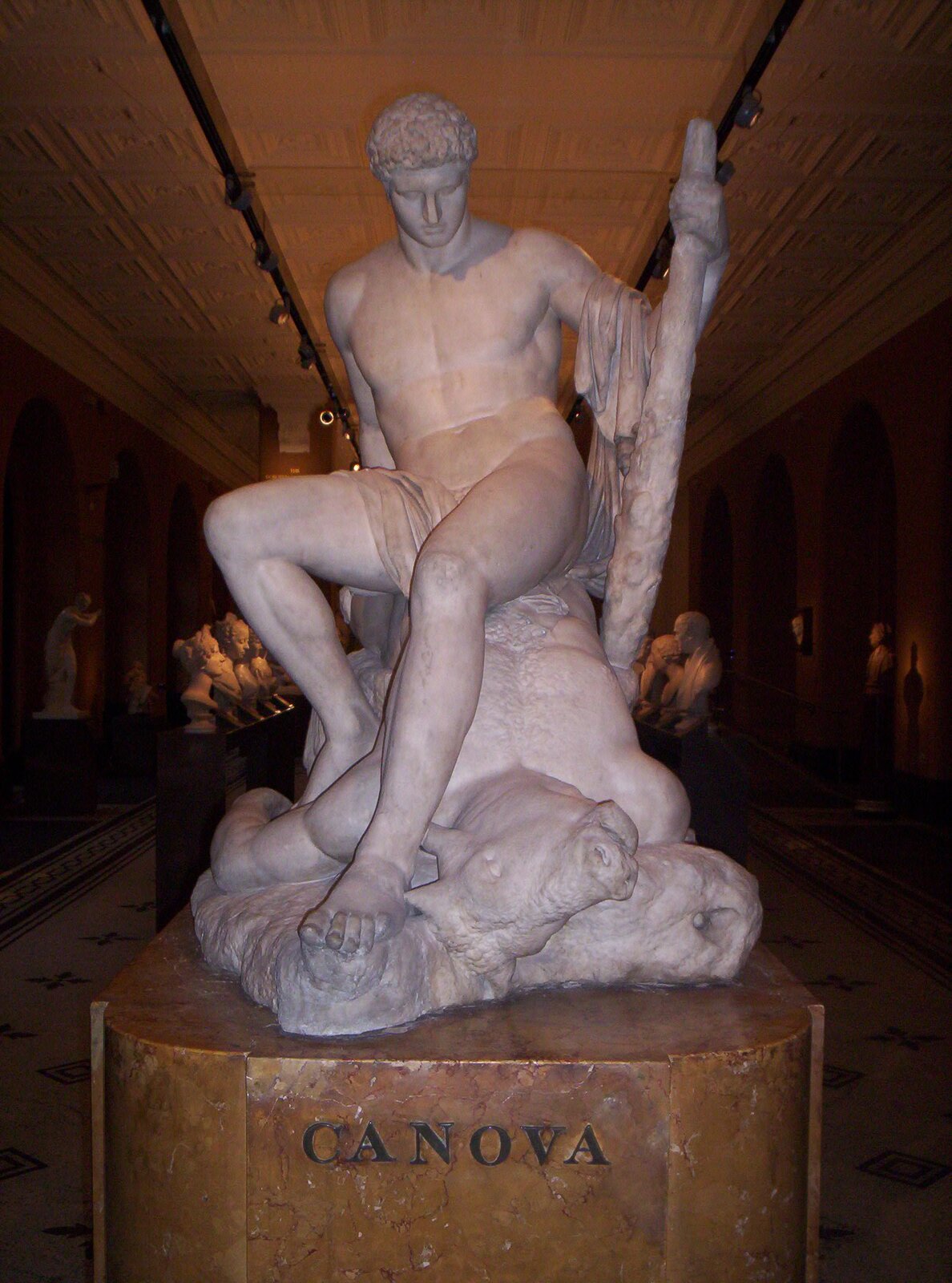 Ilustracja przedstawia rzeźbę „Tezeusz” autorstwa Antonio Canovy. Marmurowa rzeźba przedstawia muskularną postać Tezeusza obalającego Minotaura. Tezeusz spogląda na pokonanego przeciwnika.