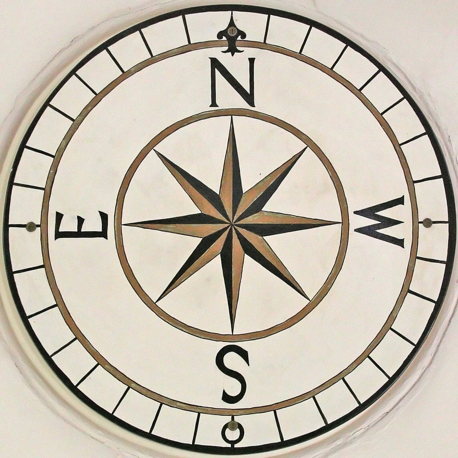 Zdjęcie przedstawia różę wiatrów. Wskazuje ona cztery kierunki świata. N oznacza północ, S oznacza południe, E oznacza wschód, W oznacza zachód.