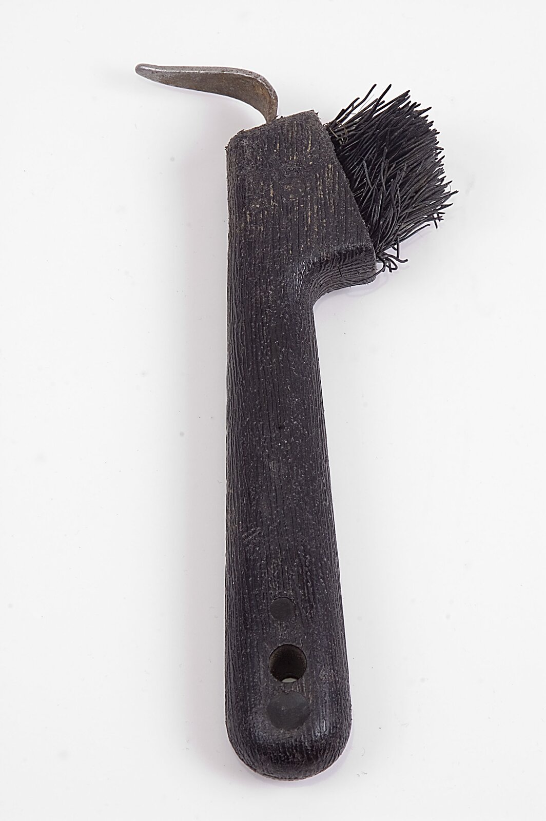 Zdjęcie przedstawiające kopystkę ze szczotką. Jest to narzędzie składające się z drewnianego trzonka, który z jednej strony ma szczotkę, natomiast z drugiej spłaszczony i ostro zakończony haczyk.