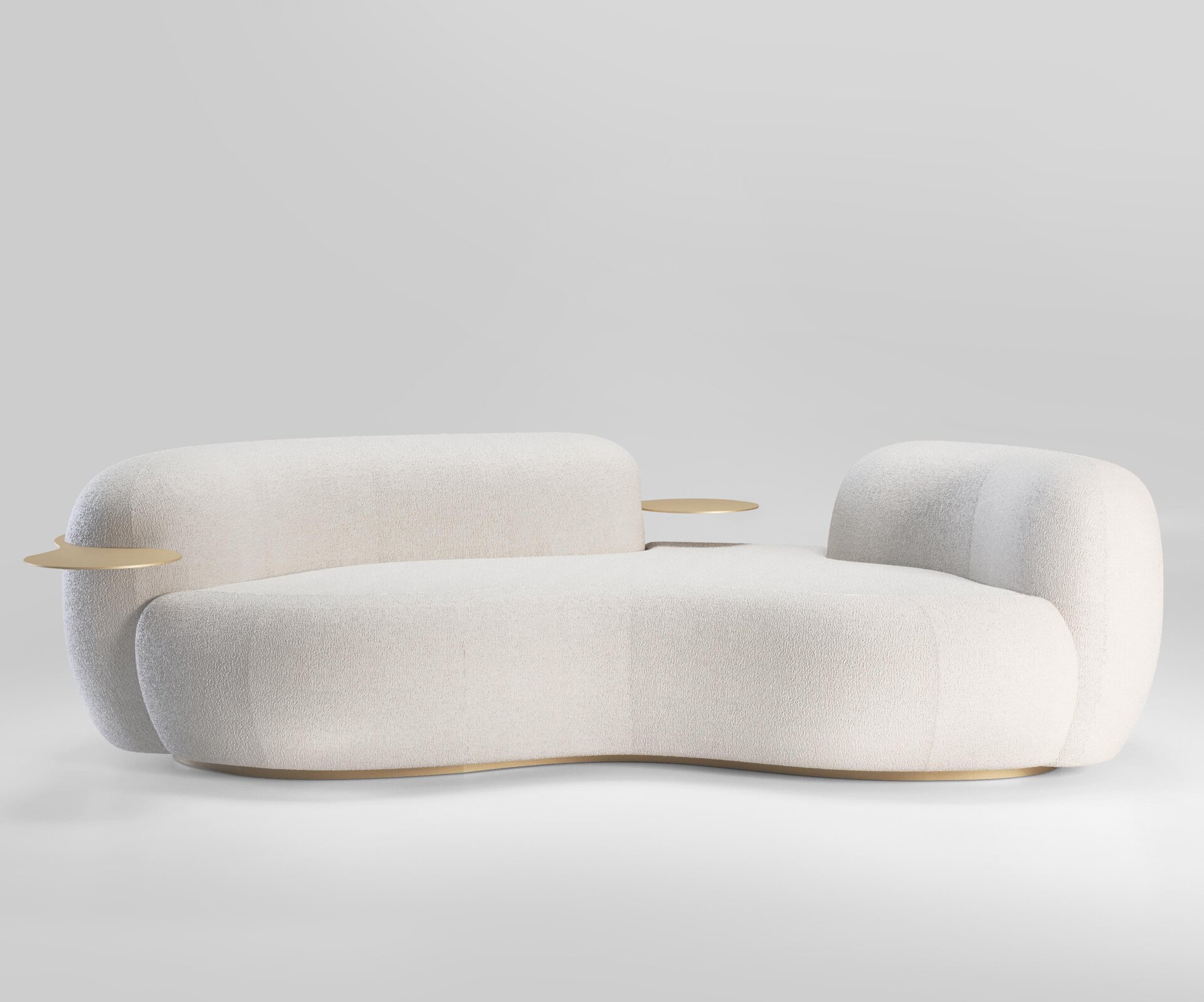 Na fotografii widoczna jest sofa wykonana z białego materiału. Jej brzegi są zaokrąglone, pozbawiona jest zagłówka. Boki sofy – tworzące oparcie, są wyższe niż część przeznczona do siedzenia, większy z nich posiada także wbudowaną część przypominającą okrągły kawałek deski przechodzący poziomo przez jego środek i tworzący pewnego rodzaju mały stolik z obu jego stron. Fotografię wykonano w jasnym pomieszczeniu, zauważalny jest cień sofy.