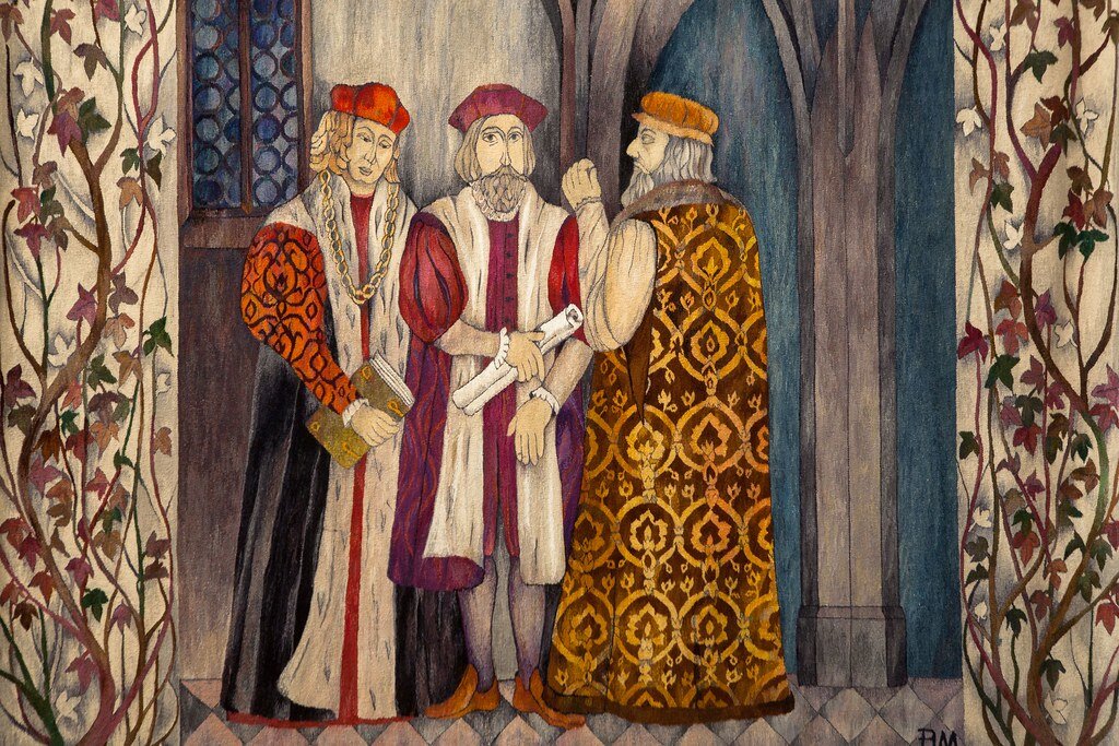 Obraz przedstawia trzech mężczyzn w szesnastowiecznych strojach dworskich. Mężczyźni rozmawiają ze sobą.