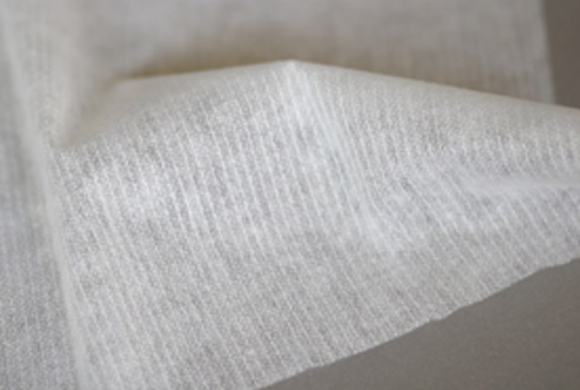 Zdjęcie przedstawia kawałek materiału w beżowym kolorze.