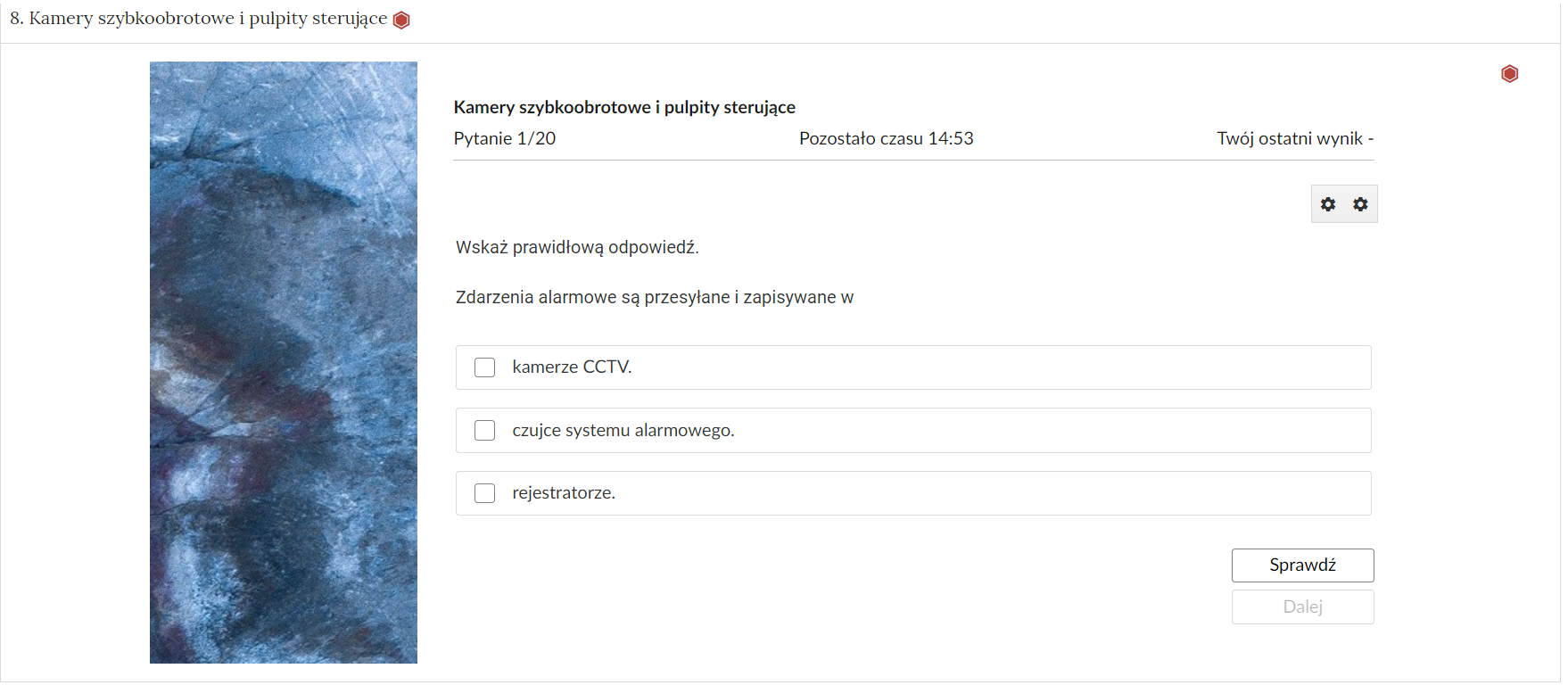 Grafika przedstawia przykładowe zadanie testowe. Ponad poleceniem widać numer pytania, czas, który pozostał na wypełnianie testu, oraz ostatni uzyskany wynik. Pod poleceniem znajdują się możliwe odpowiedzi. W prawym dolnym rogu panelu z zadaniem znajdują się dwa przyciski. Są to Sprawdź oraz Dalej.