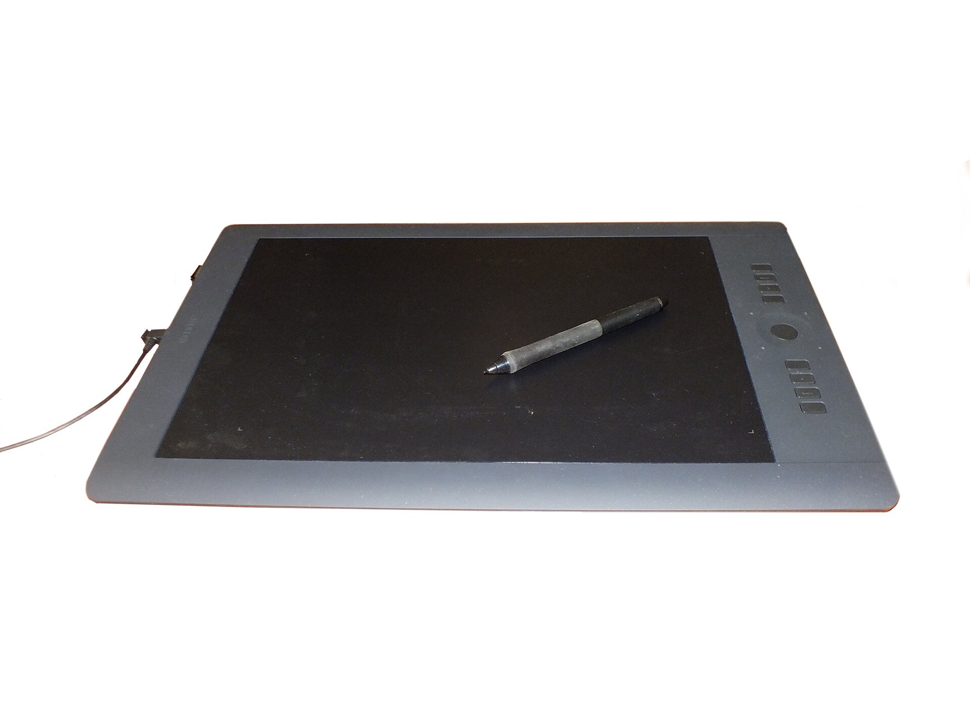 Fotografia przedstawiająca tablet graficzny z czarnym ekranem i położonym na nim specjalnym pisakiem. 