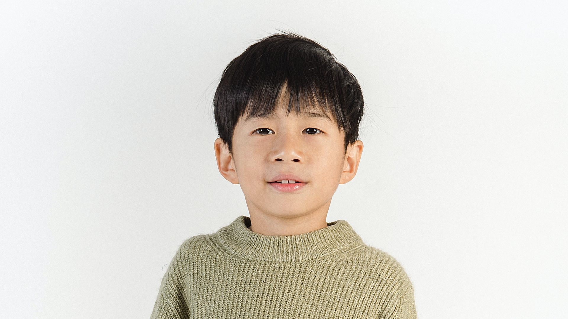 Zdjęcie przedstawia młodego chłopca z ciemnymi włosami.