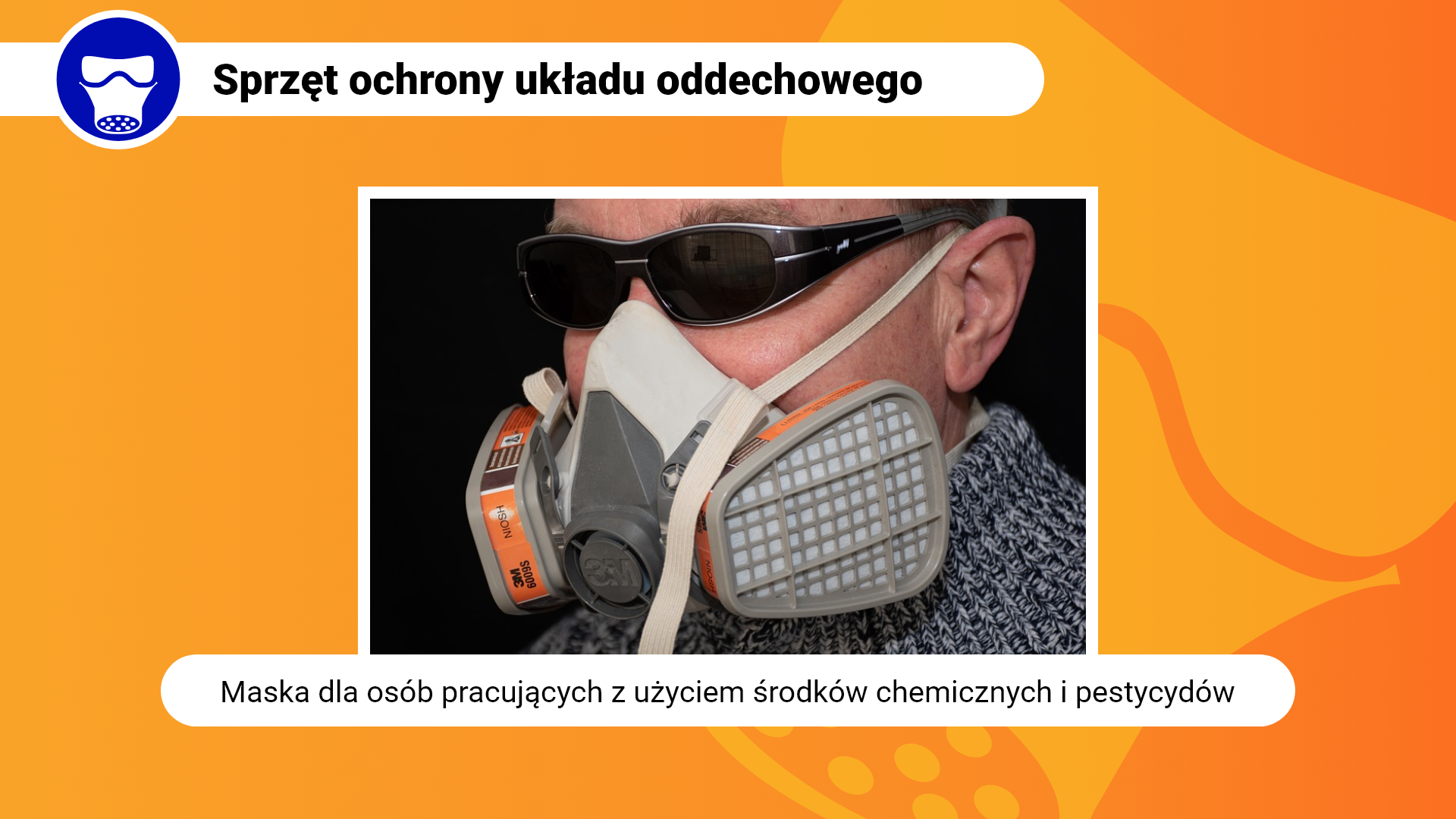 Zdjęcie w ramce z podpisem: maska dla osób pracujących z użyciem środków chemicznych i pestycydów. Przedstawia zbliżenie na głowę mężczyzny w masce. Maska po bokach posiada duże filtry. Zakrywa usta i nos. Na głowę zakładana jest za pomocą elastycznej taśmy.