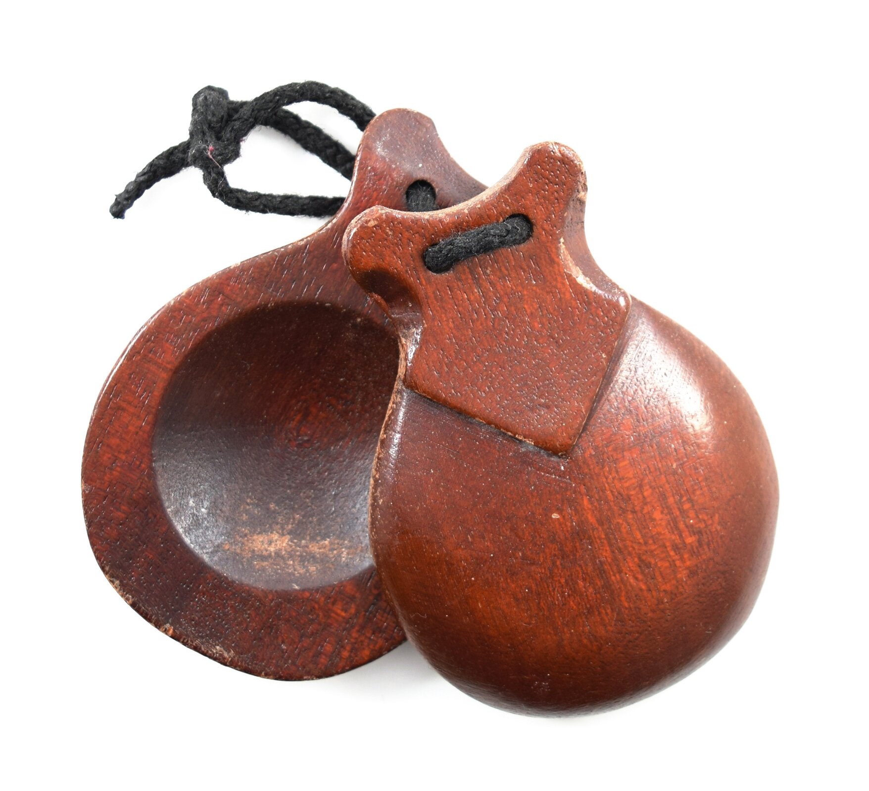 Ilustracja przedstawia kastaniety, instrument muzyczny z grupy idiofonów zderzanych, składający się z drewnianej rękojeści, do której przymocowano - z jednej lub obu stron - pary drewnianych muszelek, związanych sznurkiem. Przy potrząsaniu muszelki uderzają w znajdującą się między nimi drewnianą płytkę. 