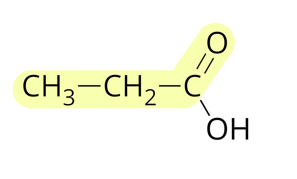 Na ilustracji ukazano wzór półstrukturalny kwasu propanowego. Od grupy C H indeks dolny, trzy, koniec indeksu dolnego odchodzi wiązanie pojedyncze w prawo do grupy C H indeks dolny, dwa, koniec indeksu dolnego, od której odchodzi wiązanie pojedyncze w prawo do węgla C. Od niego odchodzą dwa wiązania: podwójne na ukos w górę do atomu tlenu O i pojedyncze na ukos w dół do grupy O H. Grupę C H indeks dolny, trzy, koniec indeksu dolnego, C H indeks dolny, dwa, koniec indeksu dolnego, atom węgla i atom tlenu oznaczono kolorem żółtym.