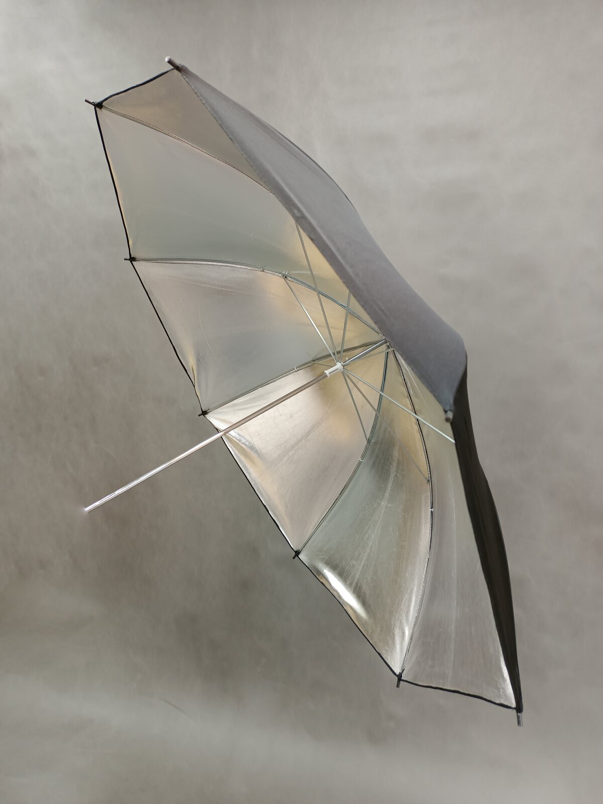 Zdjęcie przedstawia parasolkę, której materiał od wewnętrznej strony jest srebrny.