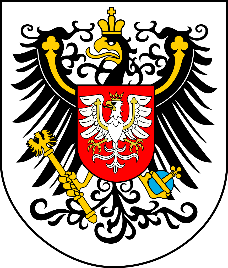 Ilustracja przedstawia herb. Znajduje się na nim czarny orzeł ze złotą koroną na głowie na białym tle. W szponach trzyma złote berło z orłem w koronie oraz niebiesko‑złote jabłko z krzyżem. Na czarnym orle znajduje się drugi, mniejszy herb. Znajduje się na nim biały orzeł z koroną na głowie na czerwonym tle.