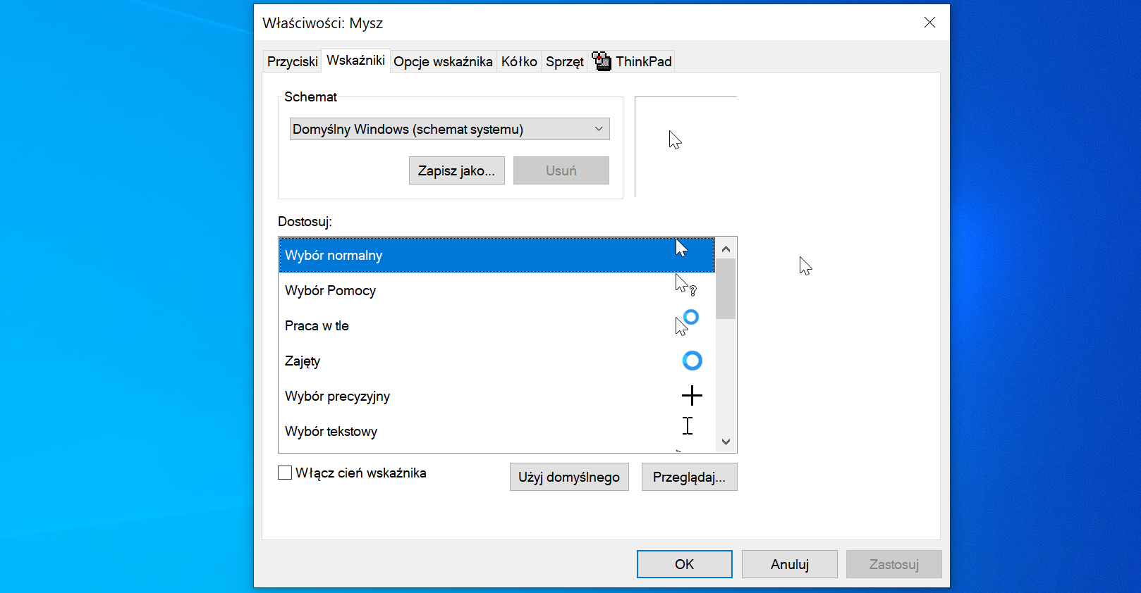 Ilustracja przedstawia okno "Właściwości Mysz" w systemie operacyjnym Windows 10. Dostępne są zakładki "Przyciski", "Wskaźniki", "Opcje wskaźnika", "Kółko", "Sprzęt", "ThinkPad". Wybrana jest zakładka "Wskaźniki", schemat ustawiony jest na "Domyślny Windows schemat systemu". Poniżej znajduje się lista kursorów do dostosowania: "Wybór normalny" (zwykły kursor), "Wybór Pomocy" (kursor z pytajnikiem), "Praca w tle" (kursor z kółkiem), "Zajęty" (kółko), "Wybór precyzyjny" (plus), "Wybór tekstowy" (kreska edycji tekstu). Opcja "Włącz cień wskaźnika" jest odznaczona. Dostępne są dwa przyciski "Użyj domyślnego" oraz "Przeglądaj..". Okno posiada u dołu przyciski "Ok", "Anuluj" oraz "Zastosuj".