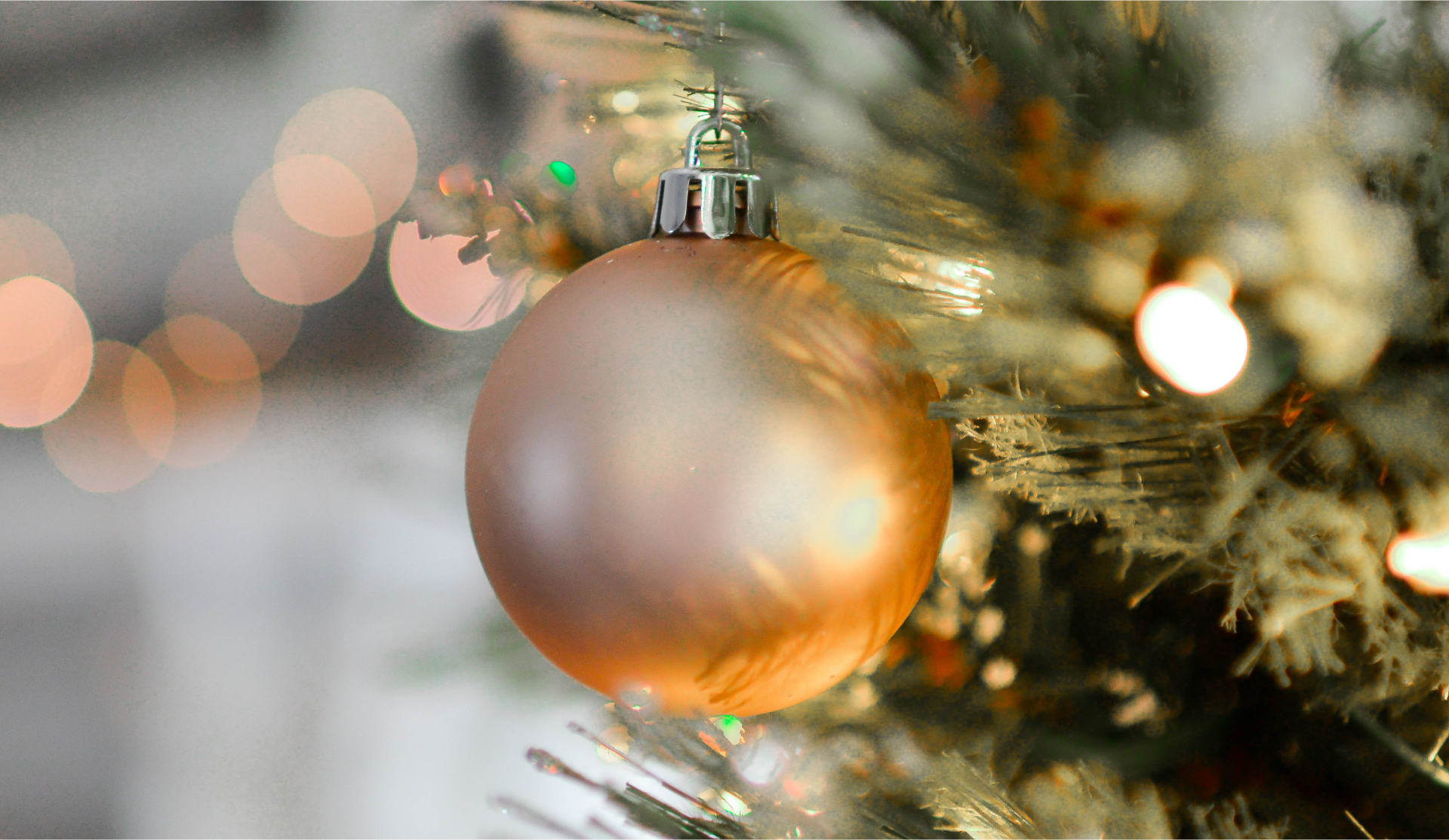 Widok ozdoby choinkowej w kształcie kuli zawieszonej na drzewku.