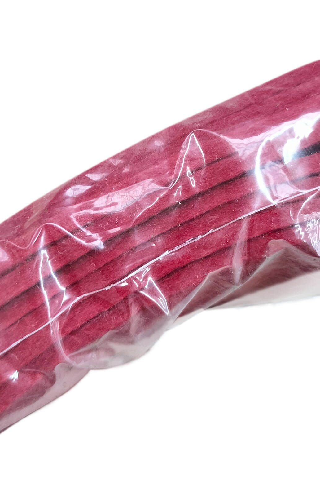 Zdjęcie przedstawia filc bity. Widoczne są płaty czerwonego filcu w ujęciu z boku, w przeźroczystym foliowym opakowaniu.