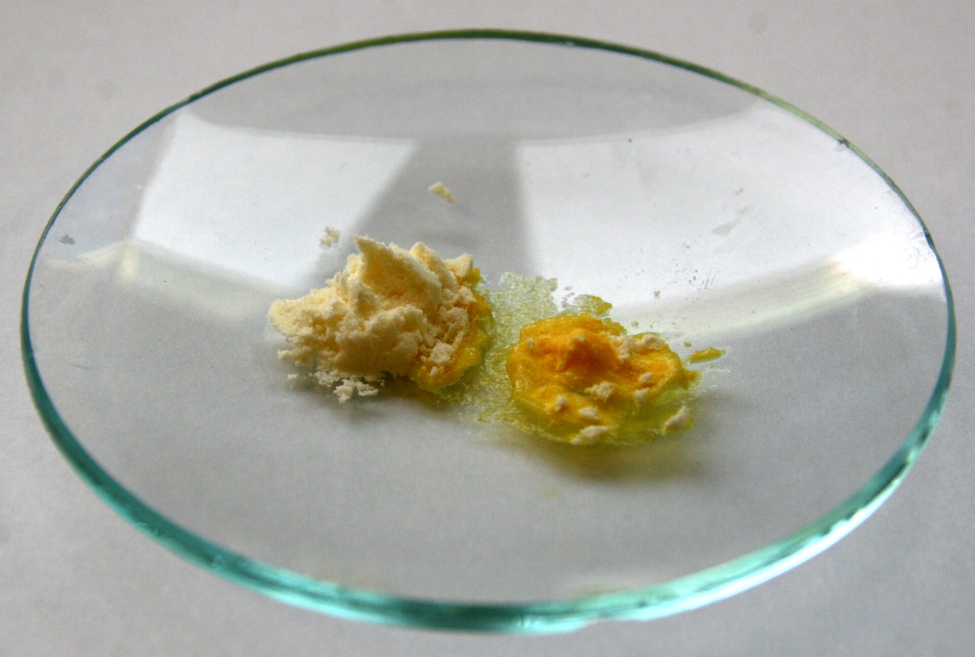 Zdjęcie przedstawiające białko potraktowane stężonym kwasem azotowym(<math aria‑label="pięc">V), które jest ścięte i przybrało zabarwienie intensywnie żółte, co jest wynikiem pozytywnej reakcji ksantoproteinowej. 