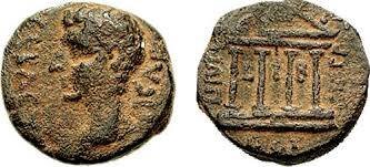 Ilustracja przedstawia awers i rewers monety o nieregularnej kształcie. Widać głowę mężczyzny oraz postument zbudowany z czterech kolumn i trójkątnego dachu.