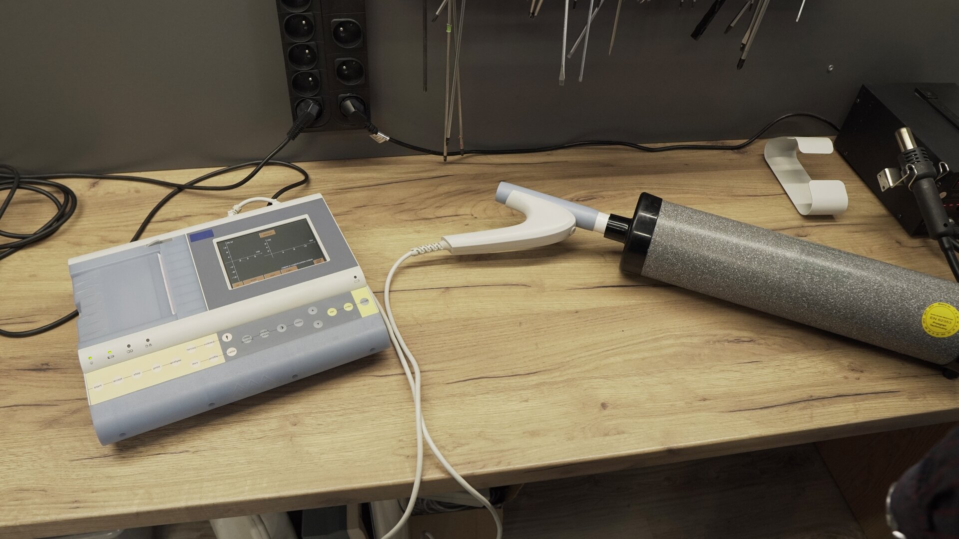 Na zdjęciu pokazany jest przetwornik podłączony do pompy kalibracyjnej oraz do spirometru. Na ekranie aparatu widoczny jest wynik testu.