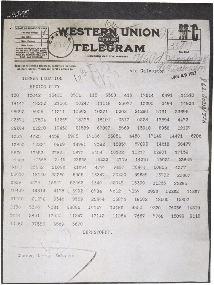 Na  ilustracji kartka papieru, na niej pogrubiony napis: WESTERN UNION TELEGRAM. Tekst w postaci ciągu liczb: trzy, cztero i pięciocyfrowych, zaszyfrowany tekst. Na kartce pieczątki oraz podpisy.