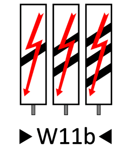 Wskaźnik wu jedenaście be. To trzy długie białe prostokąty o dłuższym pionowym boku. mają te same wymiary i są osadzone na słupku każdy. Na każdym z nich pośrodku znajdują się ukośne równoległe pasy. Na lewym jeden pas, na środkowym dwa, a na prawym trzy pasy. Na każdym prostokącie znajduje się czerwony piorun z grotem na końcu biegnący przez całą jego długość.