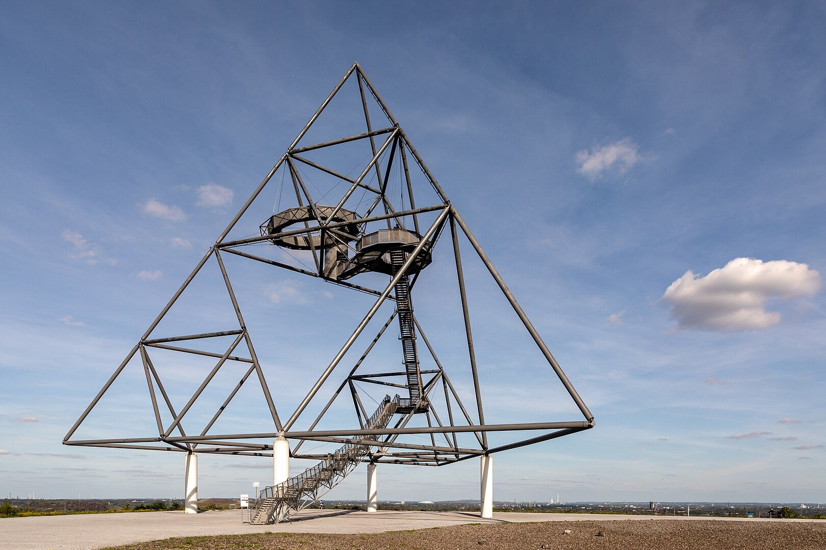 Na zdjęciu konstrukcja umieszczona na czterech kilkumetrowych filarach. Stalowa, na planie trójkąta, składa się z prostych rur. W środku przestrzeń wypełniona schodami i okrągłymi dwoma stalowymi balkonami.