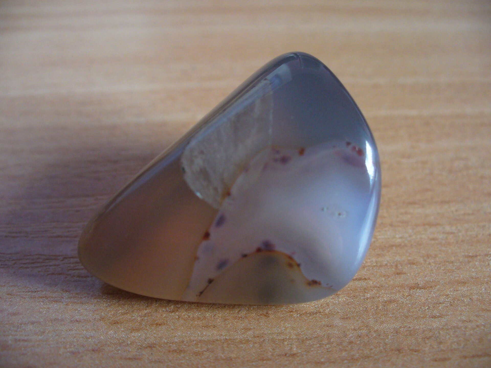 Na zdjęciu minerał o kształcie nerki. Jest niebieski i jasnobrązowy. 