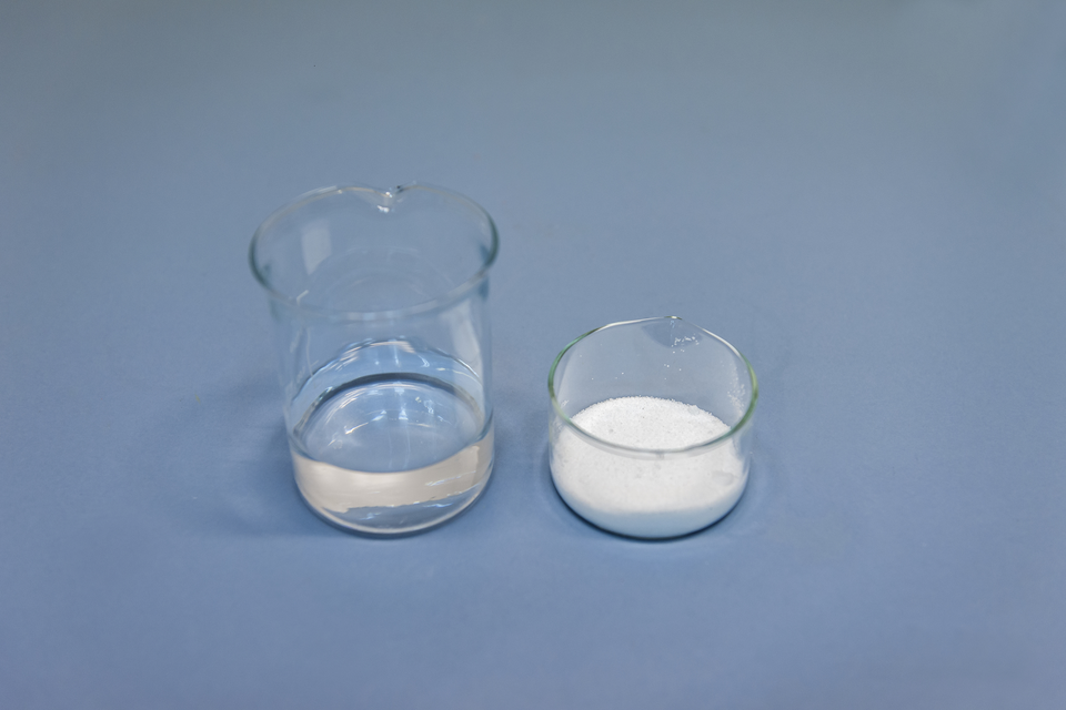 Na zdjęciu widać zlewkę, w której jest sto gramów wody. Obok niej, w szklanym naczyniu wagowym, znajduje się trzydzieści sześć gramów chlorku sodu.