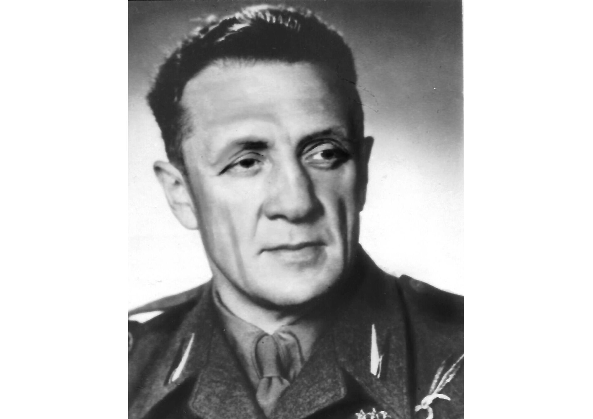 Fotografia portretowa Bolesława Kontryma, pseudonim "Żmudzin", "Biały". Mężczyzna w średnim wieku, twarz pociągła, szczupła; włosy jasne, krótkie. Głowa zwrócona w prawo. Ubrany w mundur.