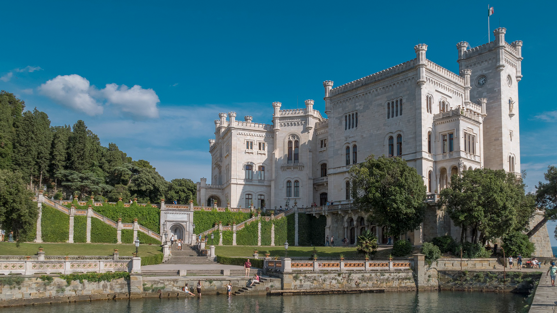 Zdjęcie przedstawia Zamek Miramare. Na pierwszym planie widoczny jest staw. 