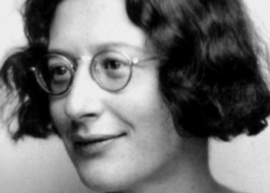 Fotografia przedstawia młodą kobietę w okularach. Ma rozpuszczone włosy za uszy i uśmiecha się.