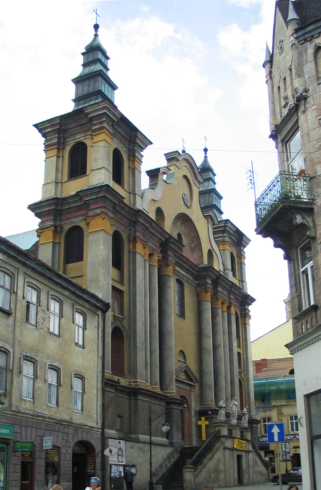 Fotografia przedstawiająca Kościół św. Marii Magdaleny w Przemyślu, 1754–1778. Budynek ma ciemną elewację. Jest zbudowany symetrycznie. Front zdobią dwie wieże zwieńczone krzyżami.