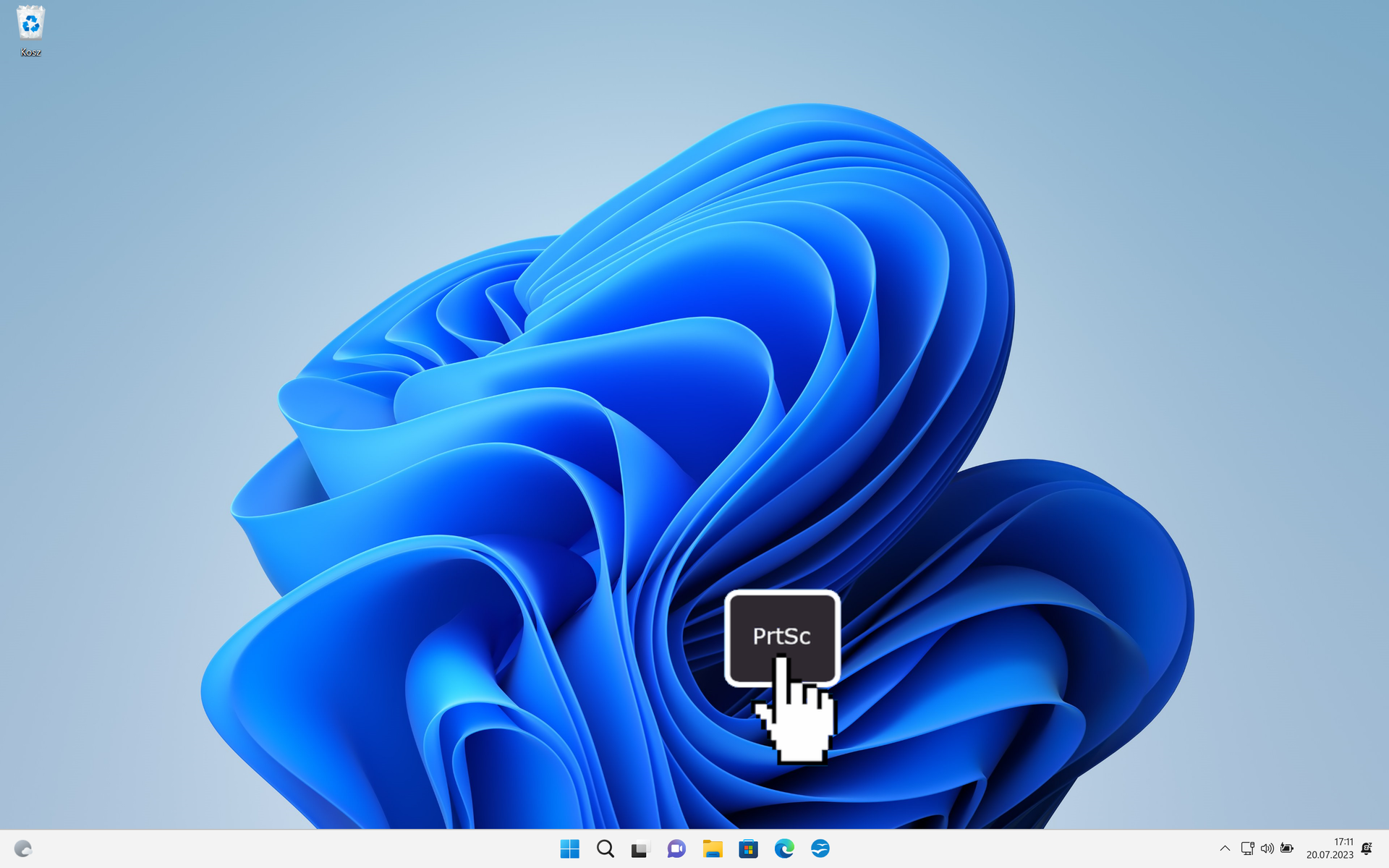 Ilustracja przedstawia pulpit systemu Windows 11. Na tapecie znajduje się niebieskie logo Windows. Na pulpicie umieszczono grafikę przedstawiającą kursor wciskający klawisz PrtSc.