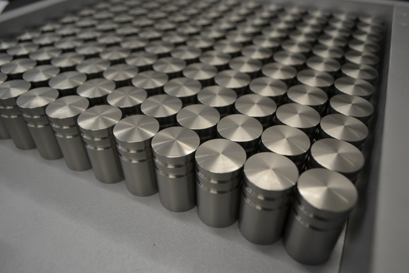 Zdjęcie przedstawia liczne walcowate elementy zbudowane ze stali austenitycznej. Mają srebrny kolor.