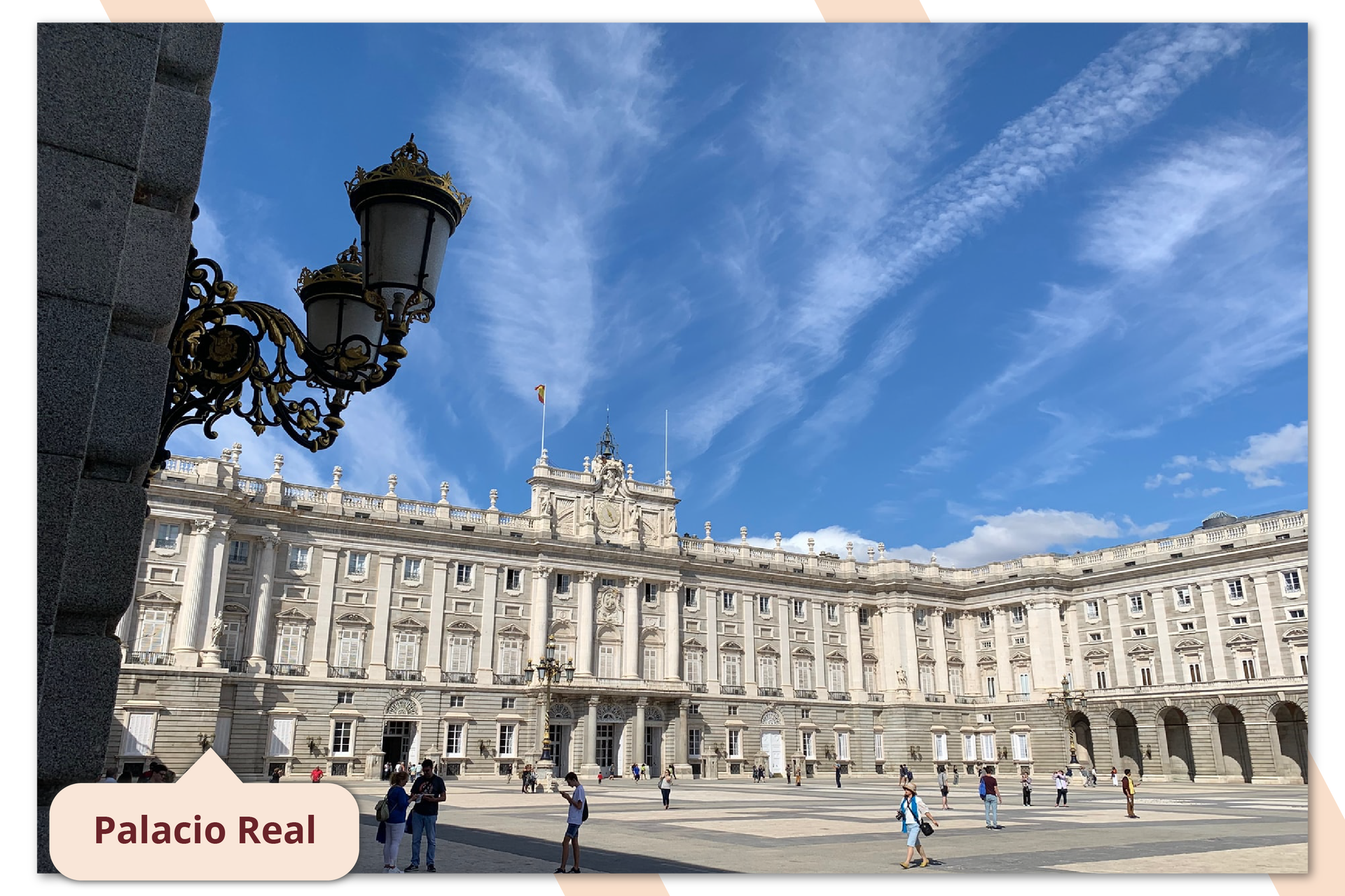 Zdjęcie przestawia fasadę Pałacu Królewskiego w Madrycie. Pałac wybudowany jest barokowym stylu. Ma jasny kolor, wiele kolumn. Podpis na zdjęciu: El Palacio Real