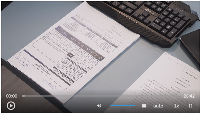 Grafika przedstawia okno programu odtwarzania filmu. Na ekranie widoczny jest dokument (faktura VAT), fragment czarnej klawiatury, oraz fragment pierwszej strony ustawy.