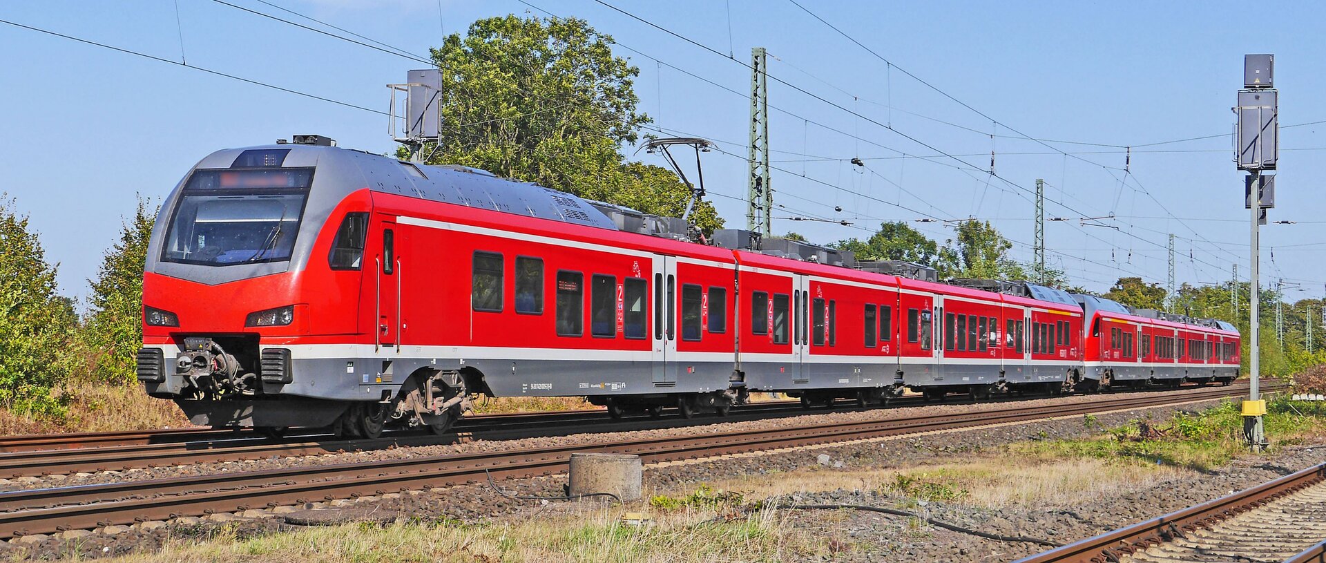 Zdjęcie przedstawia elektryczny zespół trakcyjny składający się z dwóch członów sterowniczych znajdujących się na początku i na końcu pojazdu szynowego oraz członów pośrednich przystosowanych do transportu pasażerów. Pojazd ten jest koloru czerwonego.