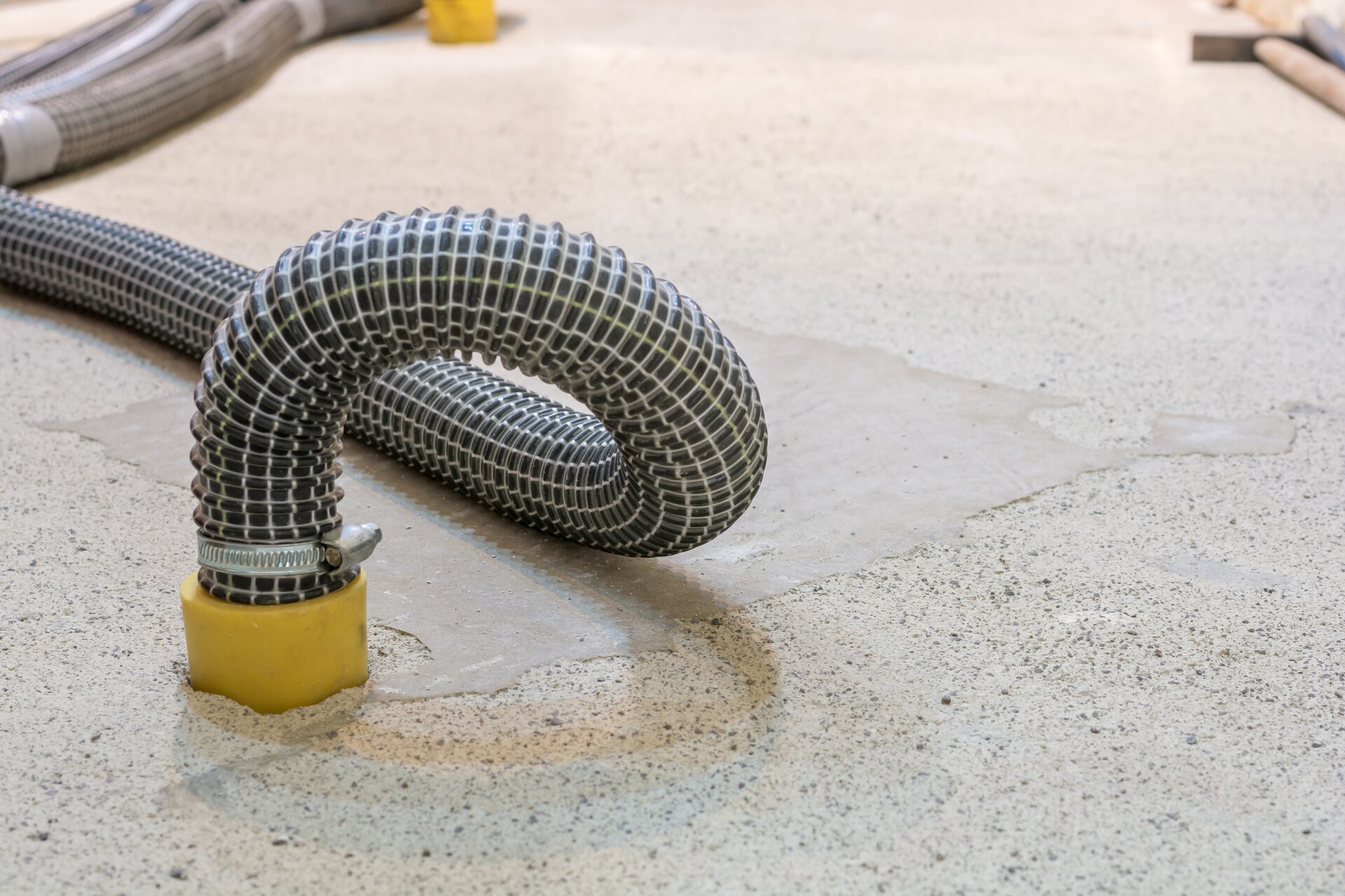 Zdjęcie przedstawia osuszanie murów metodą kondensacyjną, czyli poprzez chłodzenie powietrza poniżej punktu rosy. Widać rurę przyczepioną do muru.